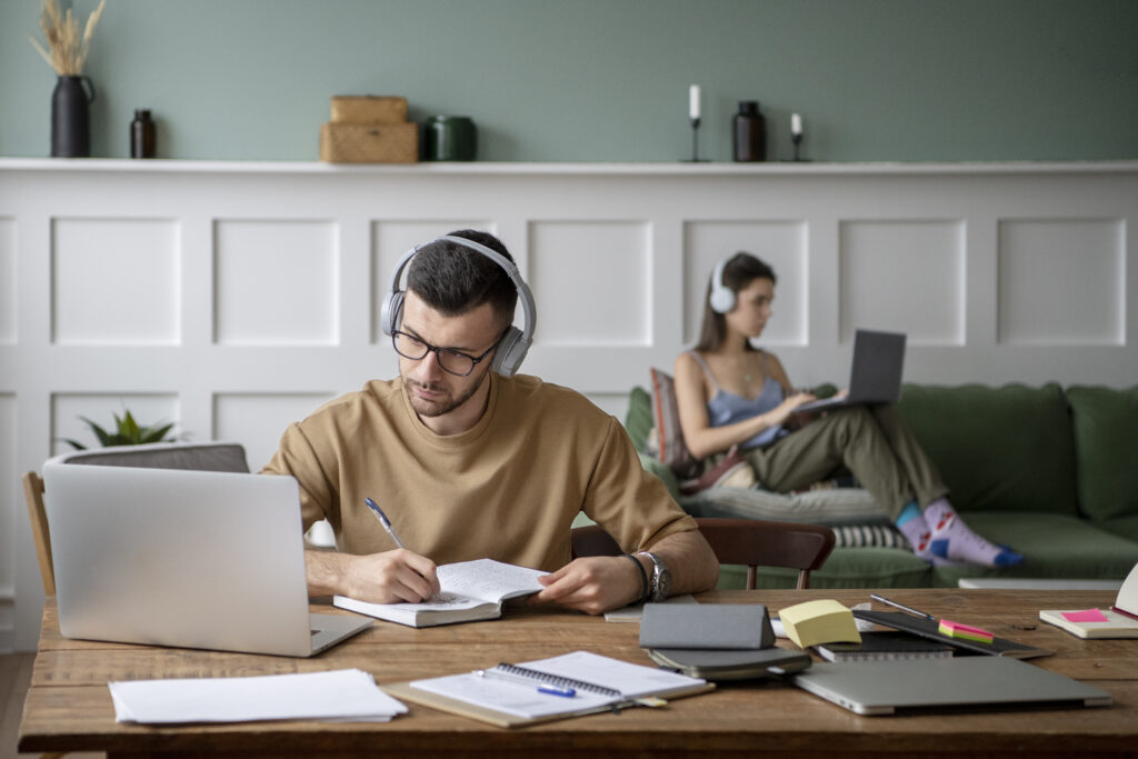 dos-amigos-que-estudian-en-una-biblioteca-usando-sus-computadoras-portatiles